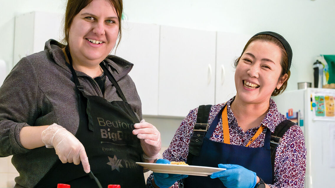 A client and support worker cooking