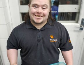 Man holding two containers smiling at camera