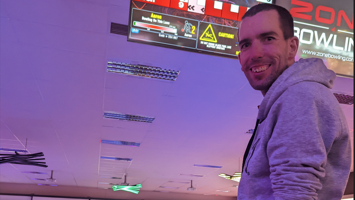 Man with bowling ball smiling