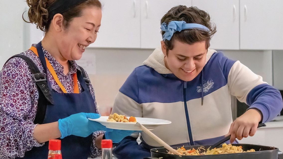 Support worker and client cook