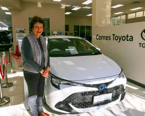 Women standing next to a white colour car