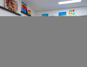 Man paining a rainbow on canvas smiling at camera