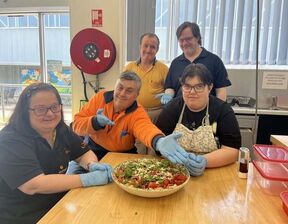 Group of people wearing gloves and food on the table