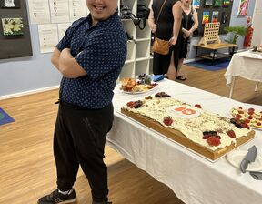 Man leaning against table with cake