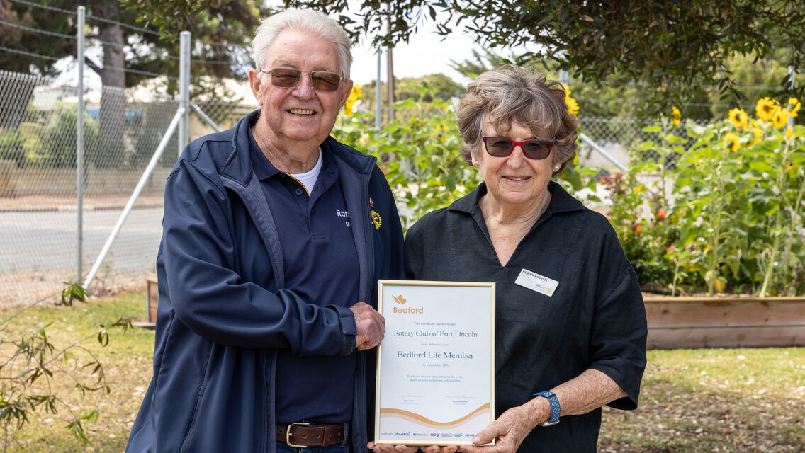 One man and women standing next to each other holding a frame