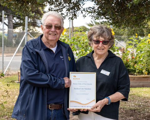 One man and women standing next to each other holding a frame