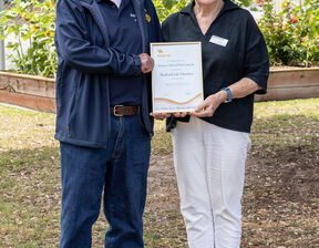 Two individuals standing and smiling at the camera