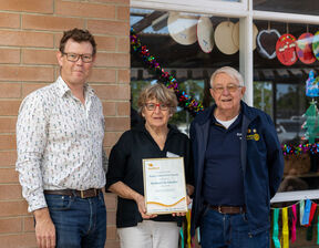 Three individuals smiling and looking at the camera