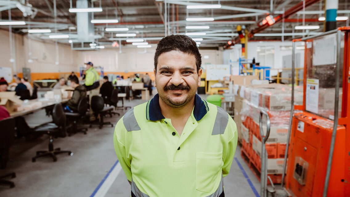 Man wearing neon yellow t shirt standing next to machines