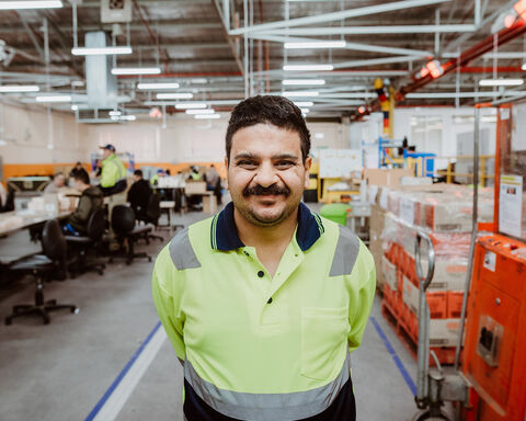 Man wearing neon yellow t shirt standing next to machines