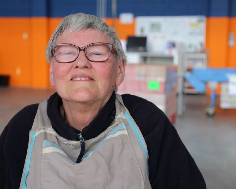 Women with glasses smiling and looking at the camera
