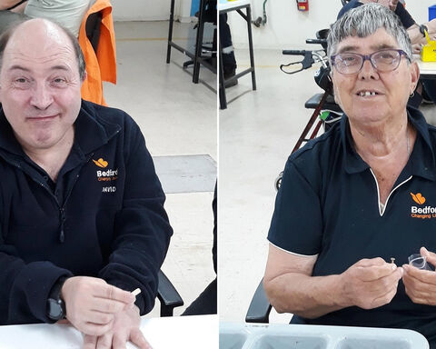 One man and women wearing navy blue Bedford Jackets smiling at the camera