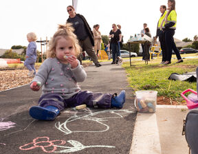Kid sitting down next to chalk drawings