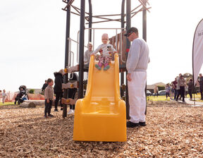 Child sliding down orange colour slide