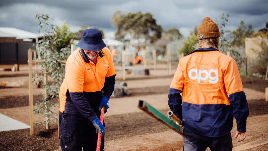Two men with apg branding maintaining gardens
