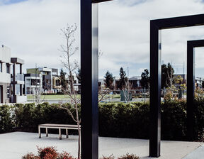 Walking path with shrubs, benches and greenery surrounding