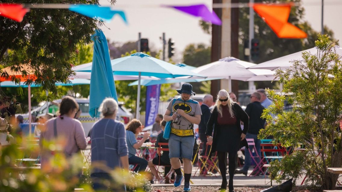 Group of people walking around with streamers on the top