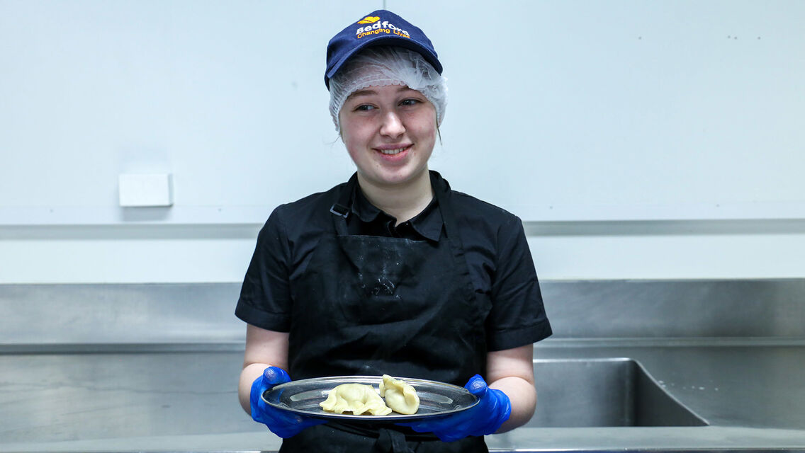 Kirra-Lea holds a tray of cooked dumplings