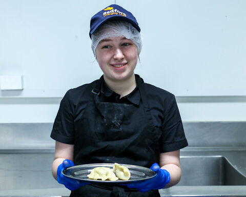 Kirra-Lea holds a tray of cooked dumplings