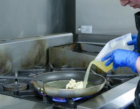A wide shot of cooking dumplings in a frying pan