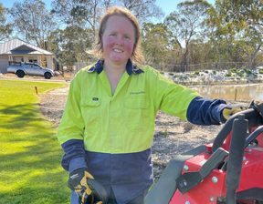 Women holding red machine smiling at the camera
