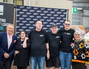 Group of individuals standing and smiling at the camera