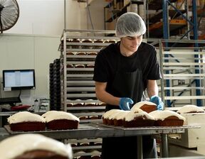 Man wearing black t shirt preparing cake