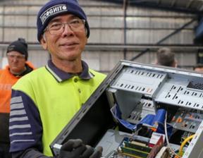 Man wearing blue colour beanie and glasses holding electronics