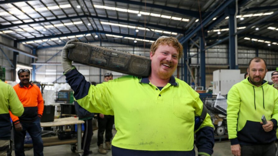 Man wearing hi-vis yellow polo with black colour speaker in hand